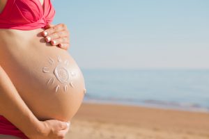 a woman on the beach with a summer pregnancy