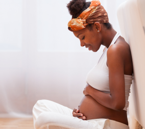 a pregnant woman holding her belly to represent fetal movement