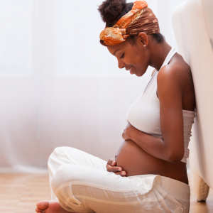 a pregnant woman holding her belly to represent fetal movement