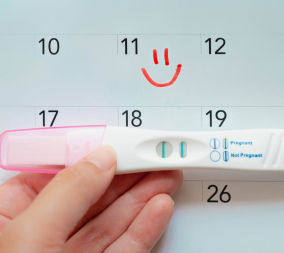 A positive pregnancy test over a calendar to represent planning for pregnancy