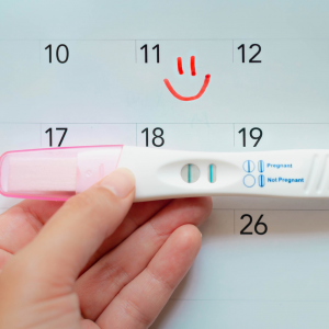 A positive pregnancy test over a calendar to represent planning for pregnancy