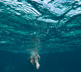 A woman swimming in the ocean to represent whether or not its safe to swim in the ocean while menstruating