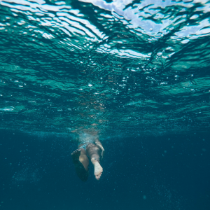 A woman swimming in the ocean to represent whether or not its safe to swim in the ocean while menstruating