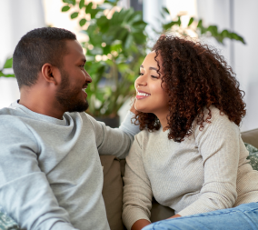 A young couple sitting on a couch having a sex talk