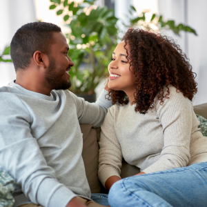 A young couple sitting on a couch having a sex talk