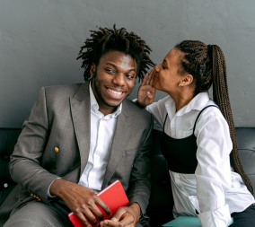 A woman whispering in a man's ear to represent the six secrets to better sex.