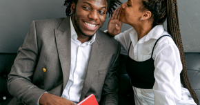 A woman whispering in a man's ear to represent the six secrets to better sex.