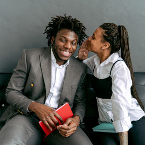 A woman whispering in a man's ear to represent the six secrets to better sex.