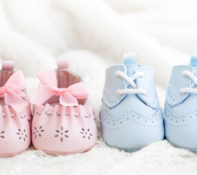 Baby shoes in pink and blue to represent the idea of morning sickness and gender