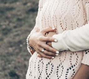 A woman cross her hands over to belly to symbolize infertility myths