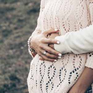 A woman cross her hands over to belly to symbolize infertility myths