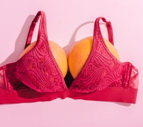 top view of bra with two oranges on pink, breasts concept, #freethenip