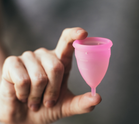 A woman holding a menstrual cup