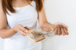 a woman dealing with postpartum hair loss