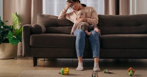 A mom hold her n=infant dealing with maternal mental health aka PMADs